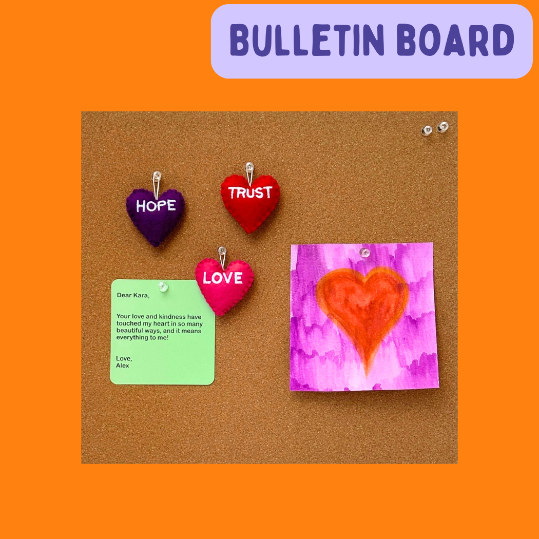 Bulletin board with a Love Heart, Hope Heart, and Trust Heart on it, and a Card with a note on it and a panting of an orange heart