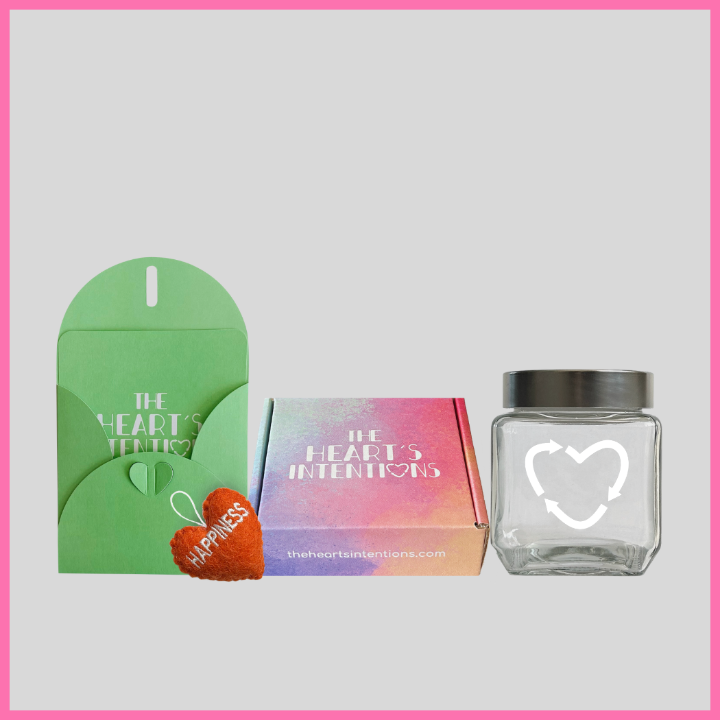 A card and envelope set with a charming heart closure alongside a heart with the word Happiness on it, beautifully presented next to a heart holder jar with a lid on it to hold your hearts and a The Heart's Intentions gift box, a meaningful way to create lasting memories through a thoughtful gift.