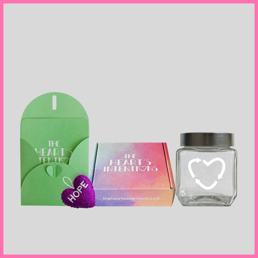 A card and envelope set with a charming heart closure alongside a heart with the word Hope on it, beautifully presented next to a heart holder jar with a lid on it to hold your hearts and a The Heart's Intentions gift box, a meaningful way to create lasting memories through a thoughtful gift.