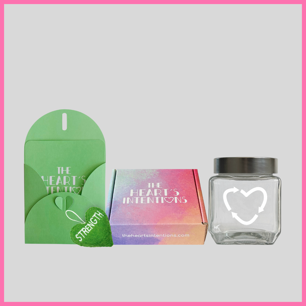 A card and envelope set with a charming heart closure alongside a heart with the word Strength on it, beautifully presented next to a heart holder jar with a lid on it to hold your hearts and a The Heart's Intentions gift box, a meaningful way to create lasting memories through a thoughtful gift.