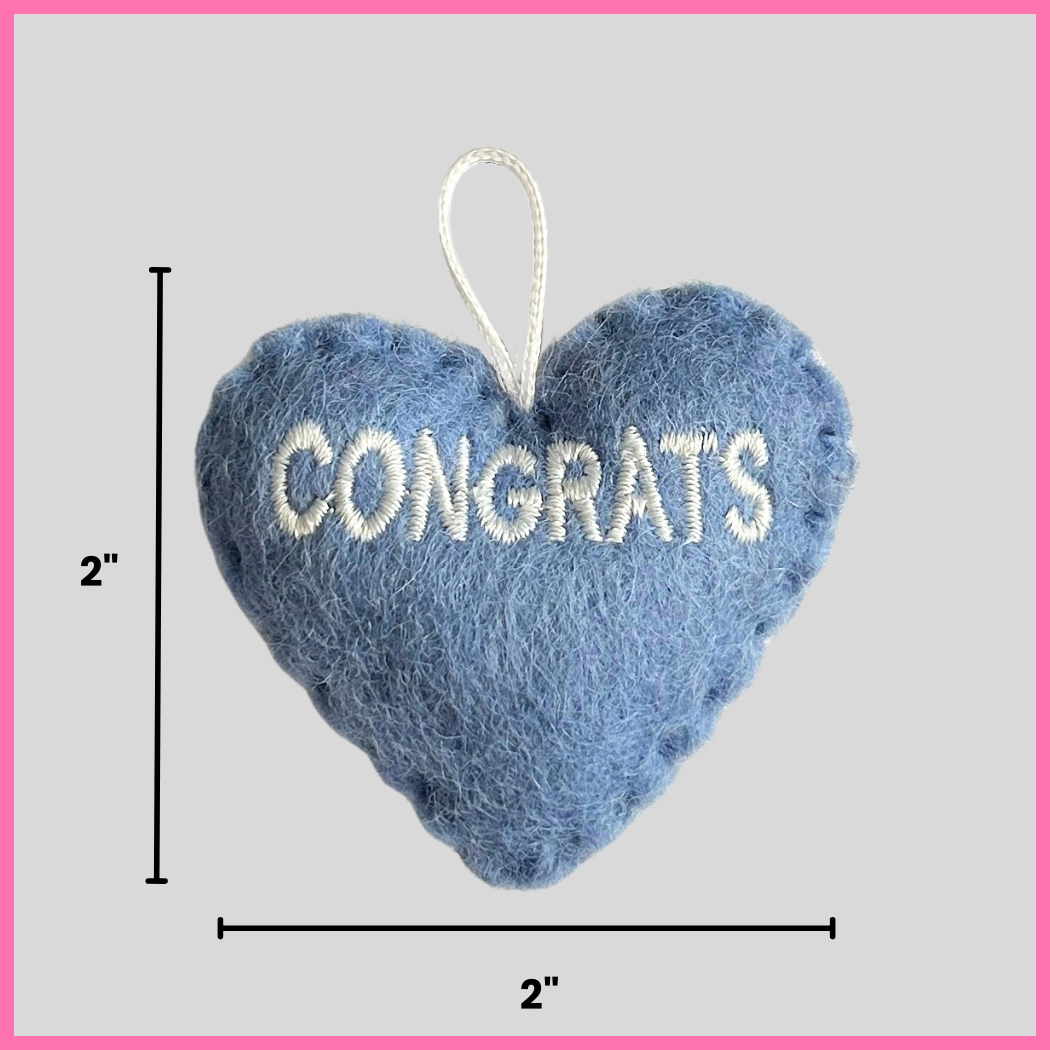 A light blue Congrats Heart showing its dimensions, two inches by two inches.