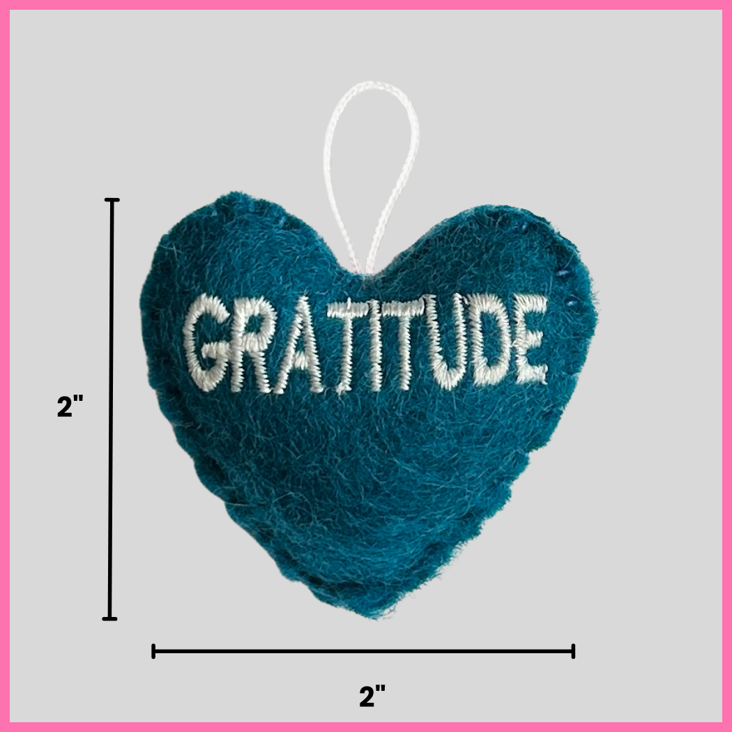 A teal Gratitude Heart showing its dimensions, two inches by two inches.