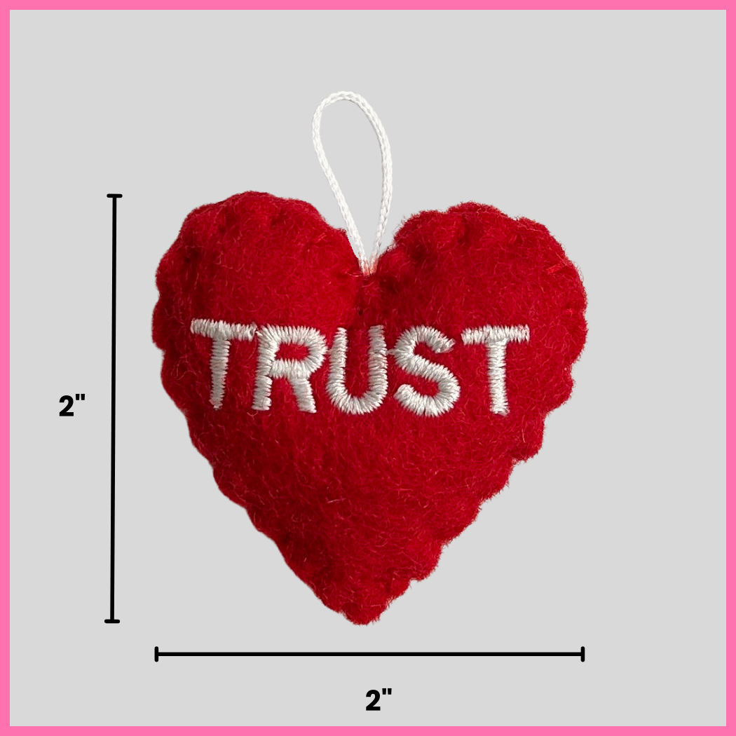 A red Trust Heart showing its dimensions, two inches by two inches.